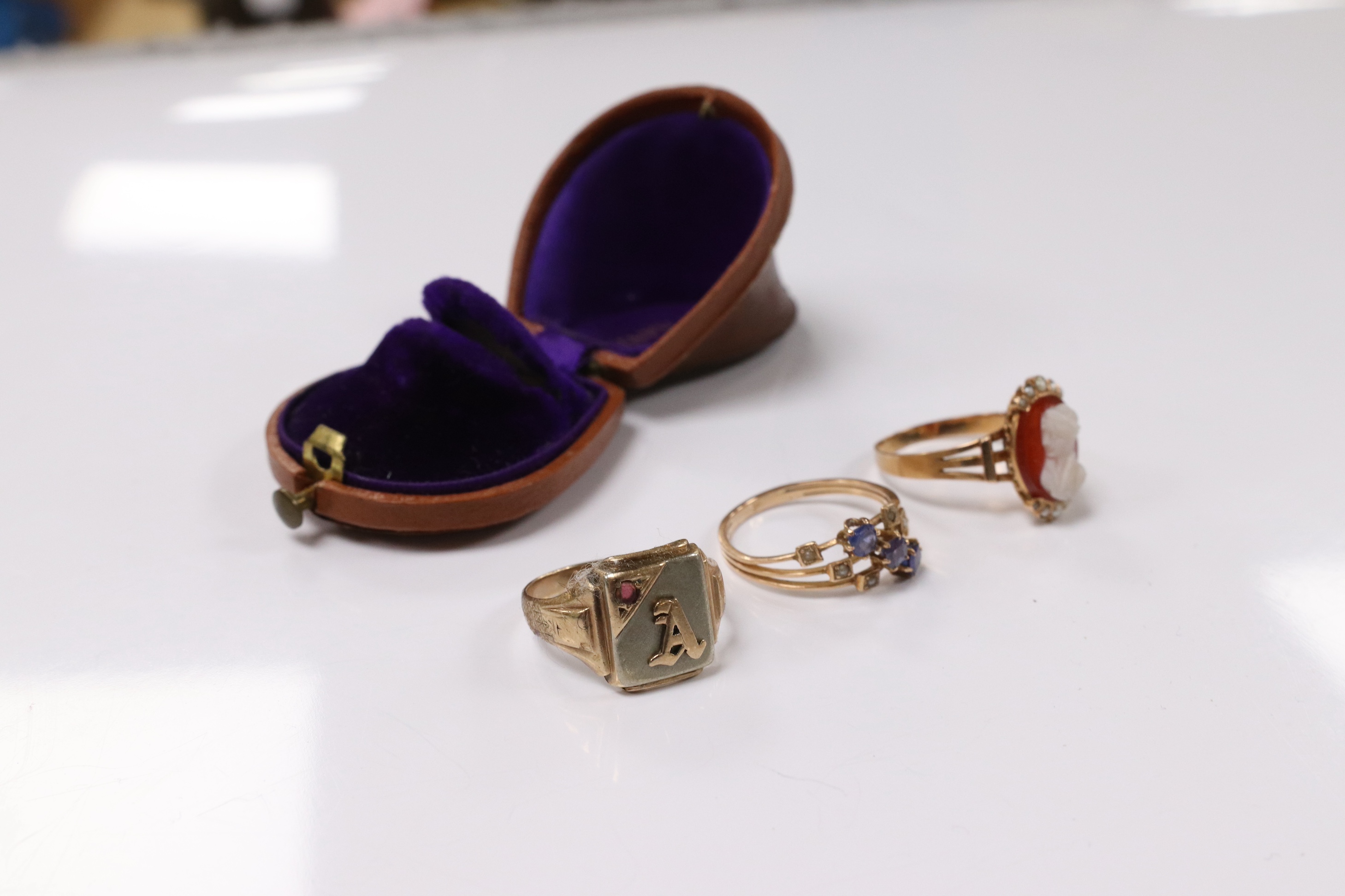 A 10k and gem set initial ring, a continental yellow metal and gem set ring and an early 20th century yellow metal, hardstone cameo and seed pearl set ring, size P, gross weight 8.2 grams. Condition - poor to fair